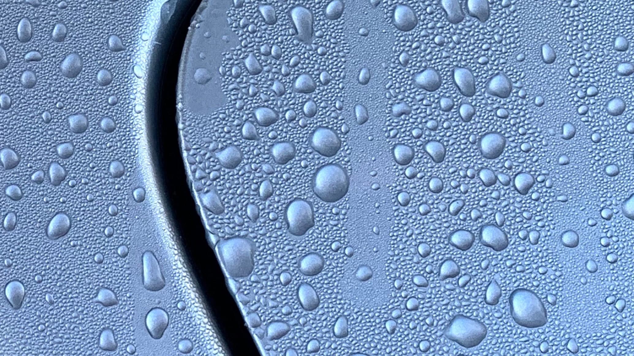 Water droplets beading on a coated metal surface